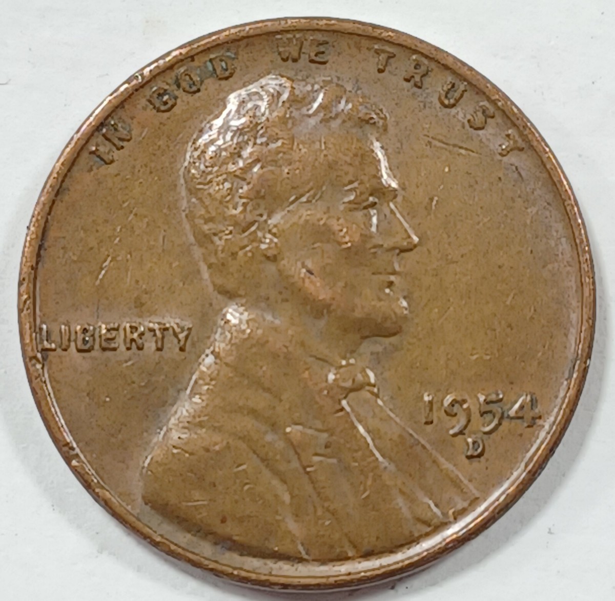 1954 wheat penny lamination error showing surface flaking and crater-like separation on the bronze planchet
